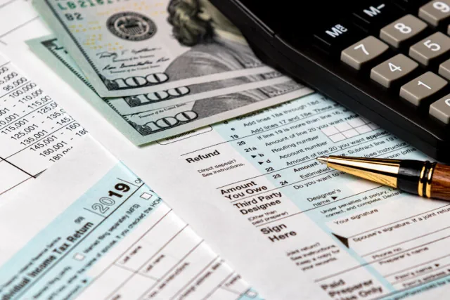 Money and Tax forms beside a calculator